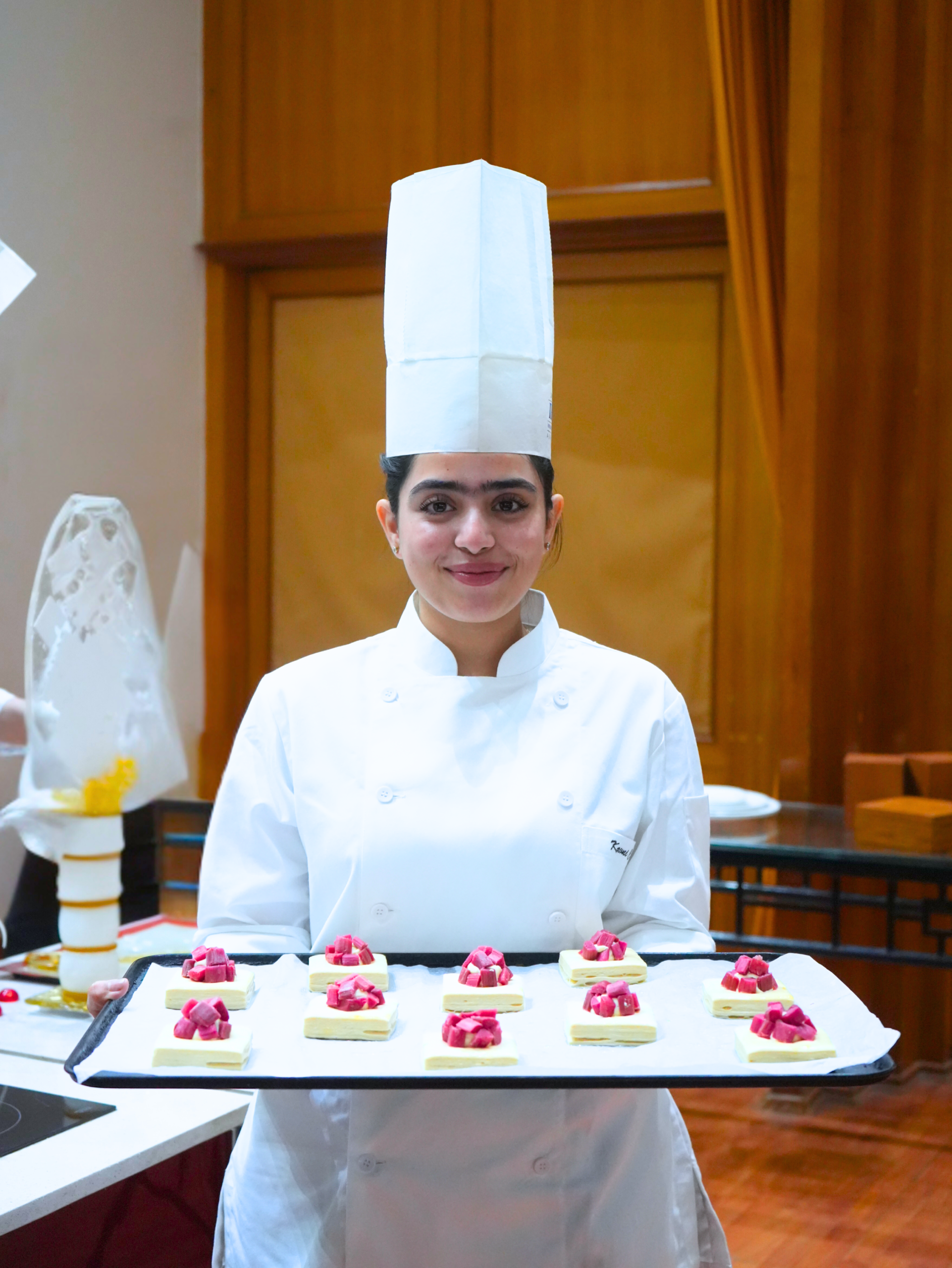 Culinary arts student presenting plated desserts in professional kitchen training at IHM Aurangabad
